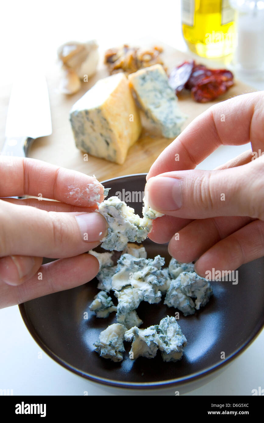 Breaking up gorgonzola cheese for a pasta sauce - with recipe Stock Photo