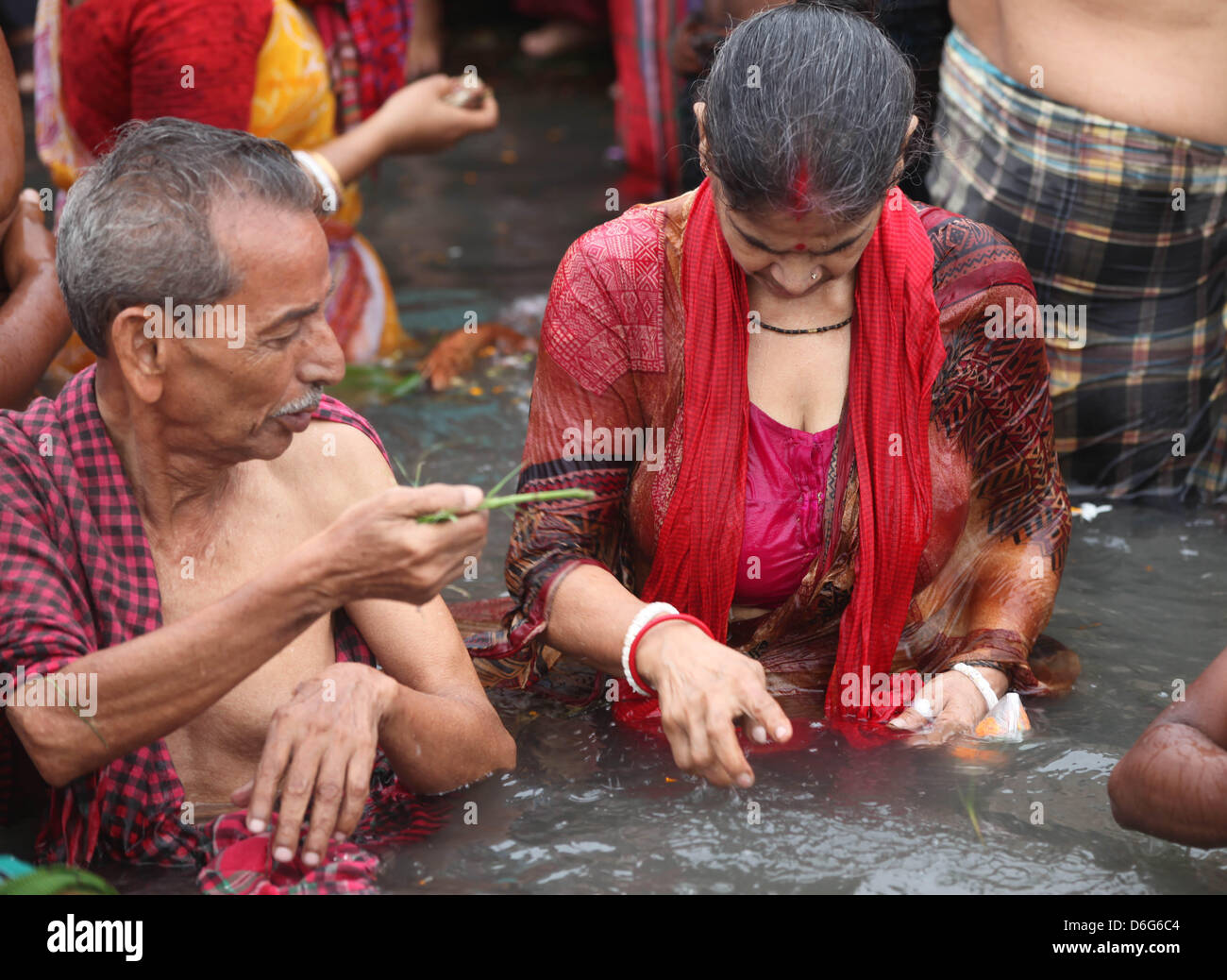 Narayangonj, Bangladesh. April 18, 2013. A Bangladeshi Hindus devotee  offers prayers and taking a dip bath in the Old Brahmaputra river near the  port town of Narayangang, 18 April 2013. Thousands of