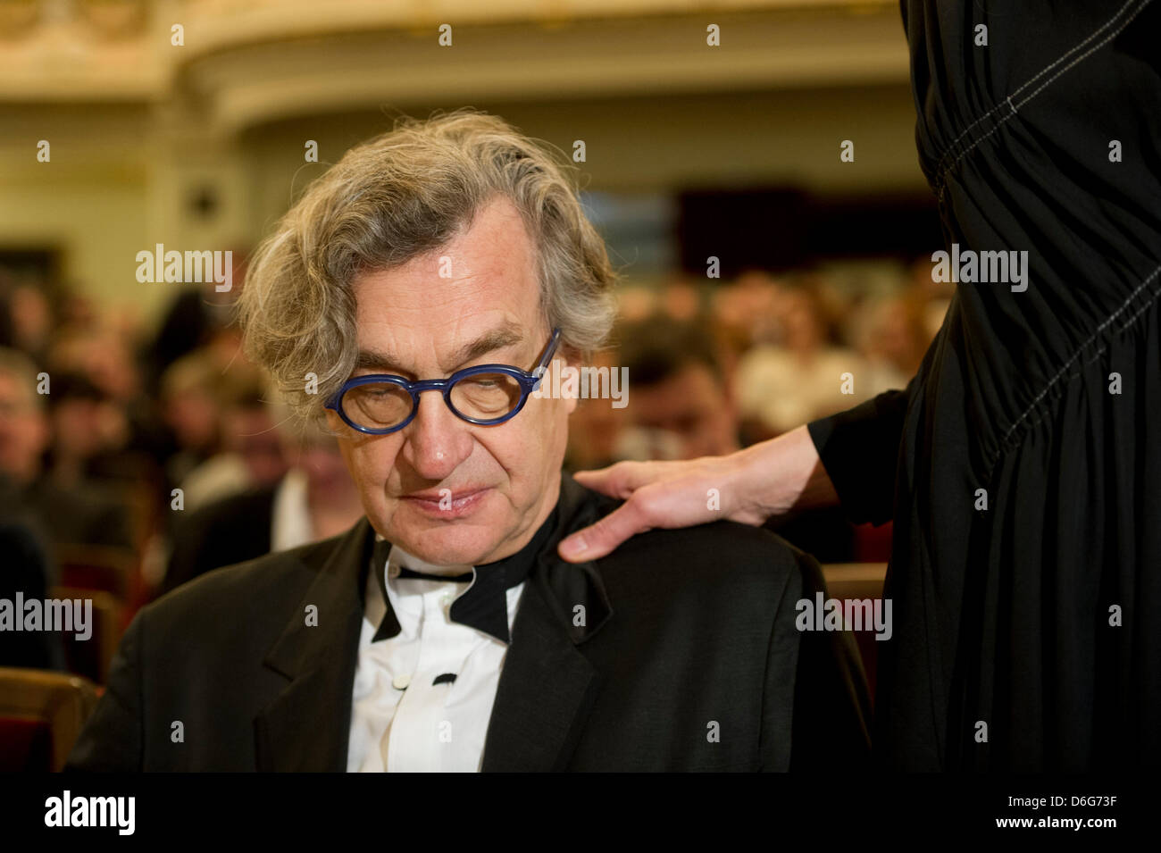 German director Wim Wenders attends the award ceremony of the gives the 3rd international peace prize, the Dresden Prize, to American documentary photographer James Nachtwey while his wife Donata puts her hand on his shoulder at the Semper Opera in Dresden, Germany, 11 February 2012. Photo: ARNO BURGI Stock Photo