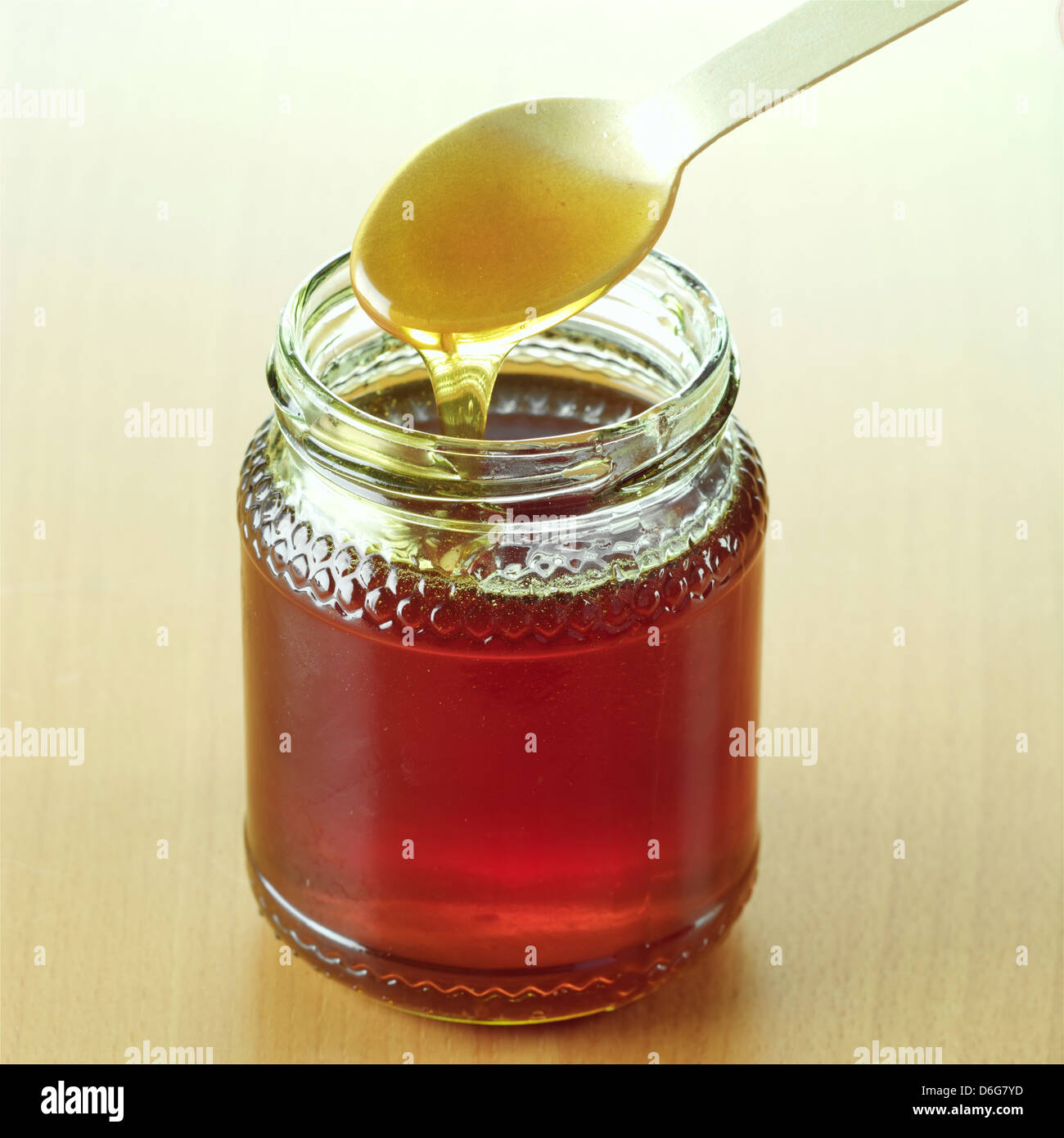 Spoon dripping honey into a jar Stock Photo - Alamy