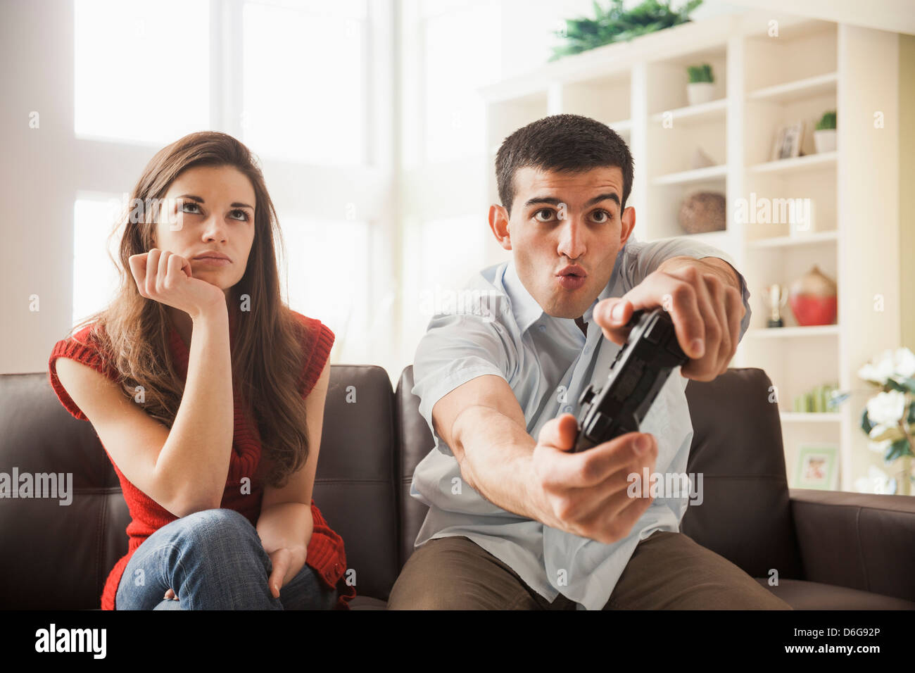 Man disappointed while playing video game with girlfriend at home stock  photo