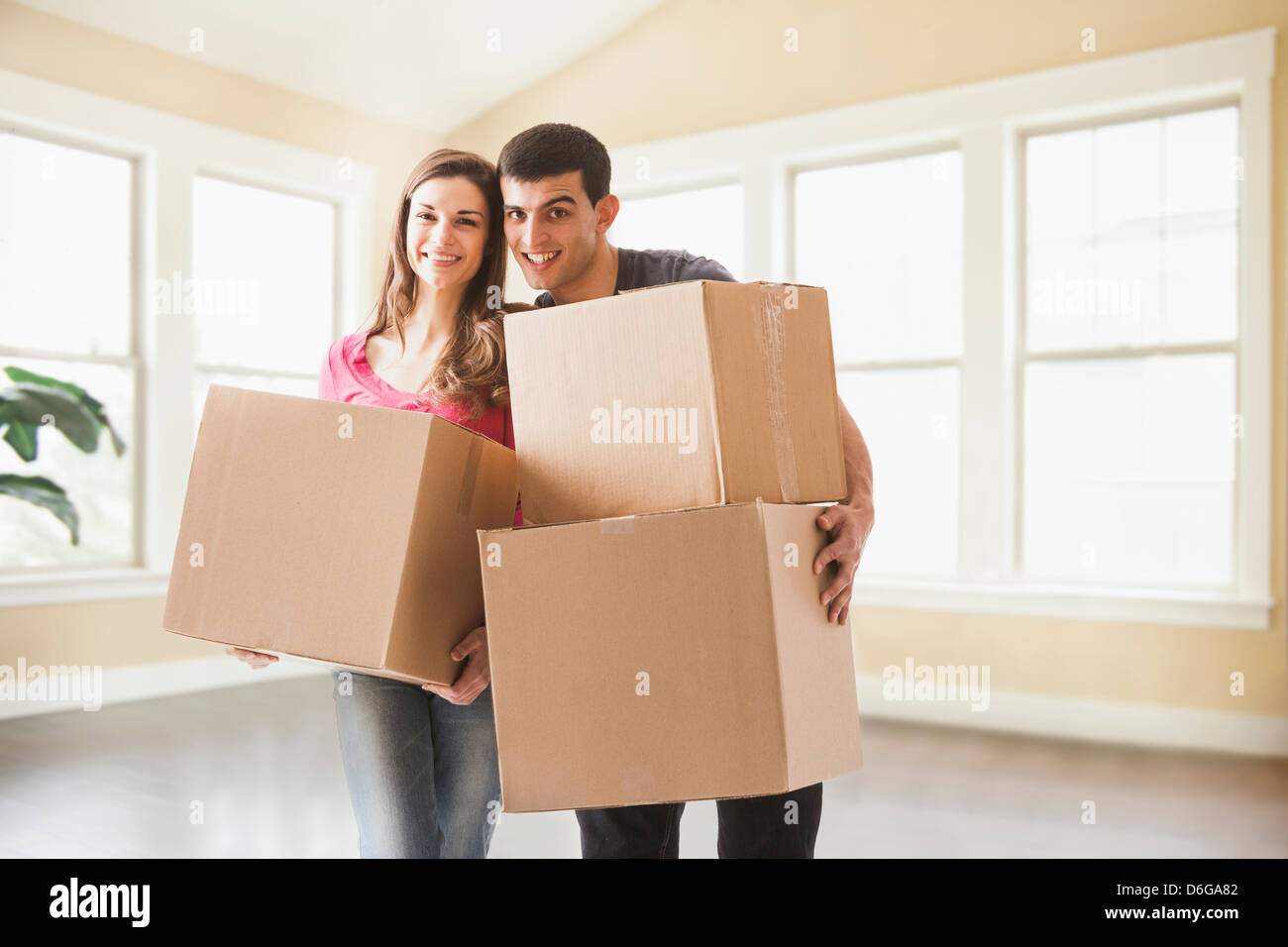 Couple carrying cardboard boxes in new home Stock Photo - Alamy