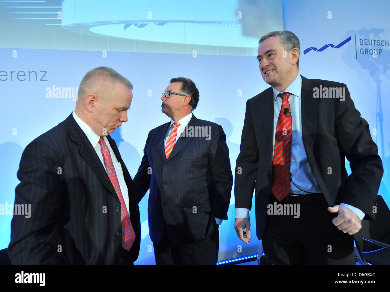 CEO of Deustche Boerse AG Reto Francioni (C) tries to arrange his fellow members of the board Gregor Pottmeyer (R) and Andreas Preuss (L) for a group picture after a press conference on the annual results in Frankfurt Main, Germany, 14 February 2012. Francioni said that 2011 was the second best year in the company's history. Photo: BORIS ROESSLER Stock Photo