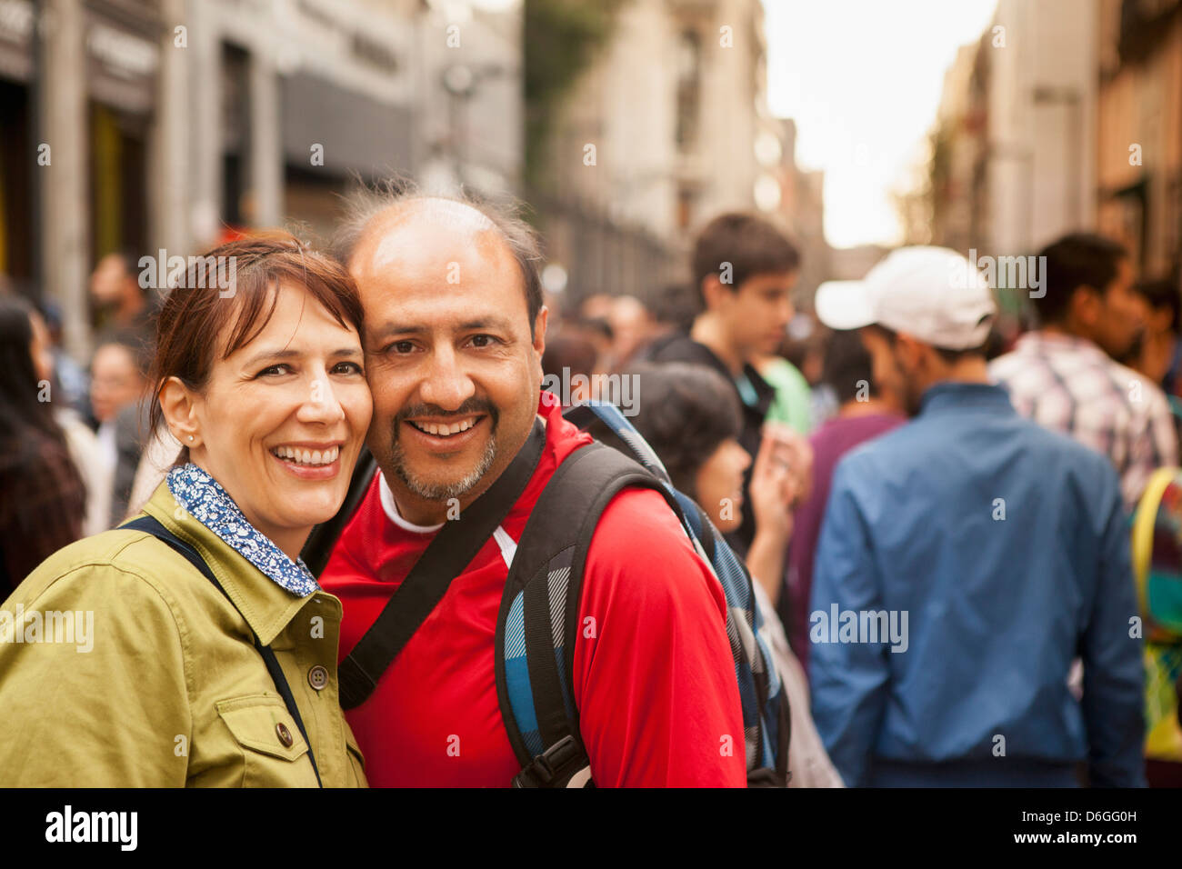 Hispanic couple smiling on city street Stock Photo