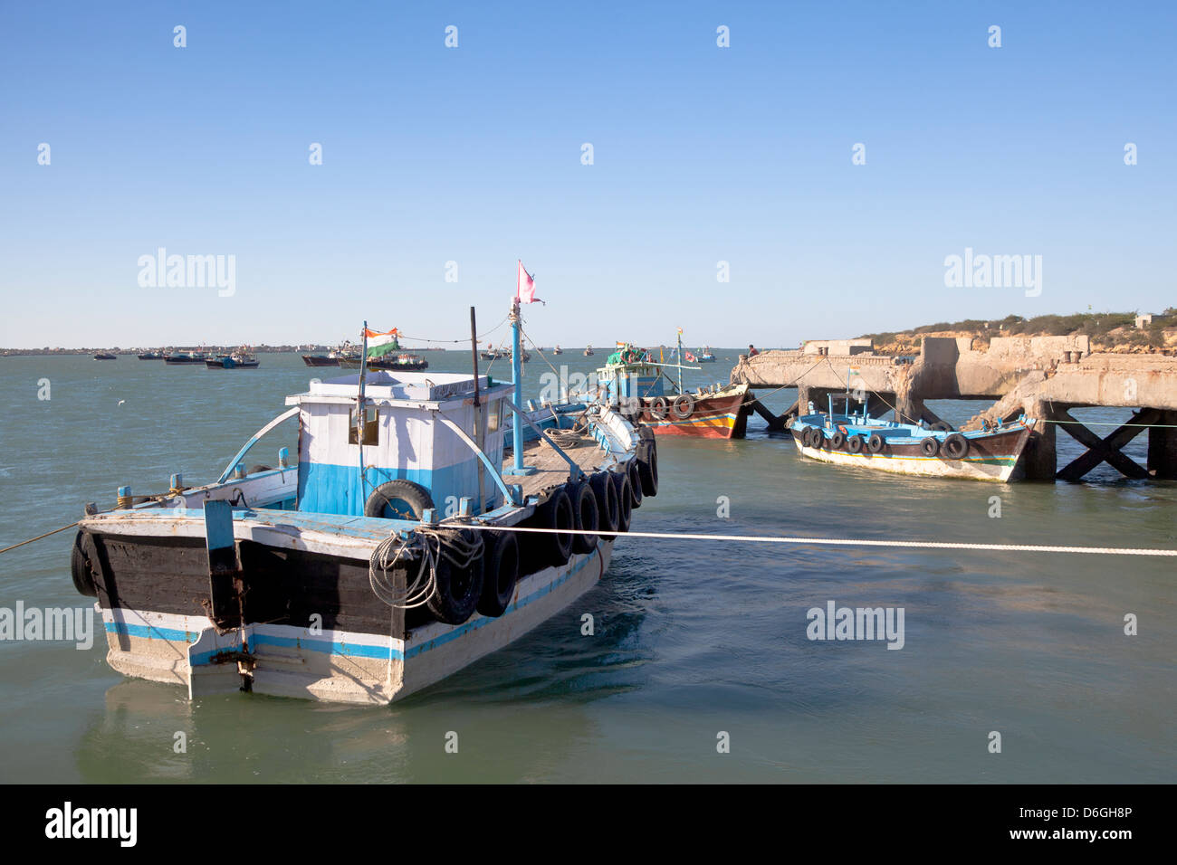 Horizontal capture of fishing boats moored at the coastline of Bet Dwarka pier late afternoon in Gujarat India Stock Photo