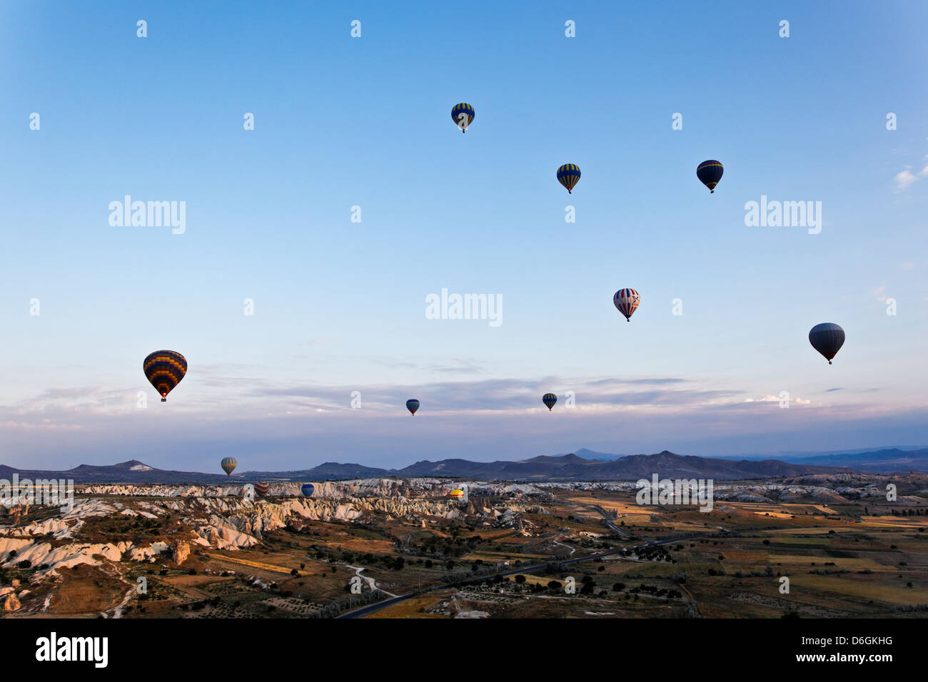 Aerial view of Cappadocia and Goreme plains with its mountains and sky filled with multi colored hot air balloons at dawn Stock Photo