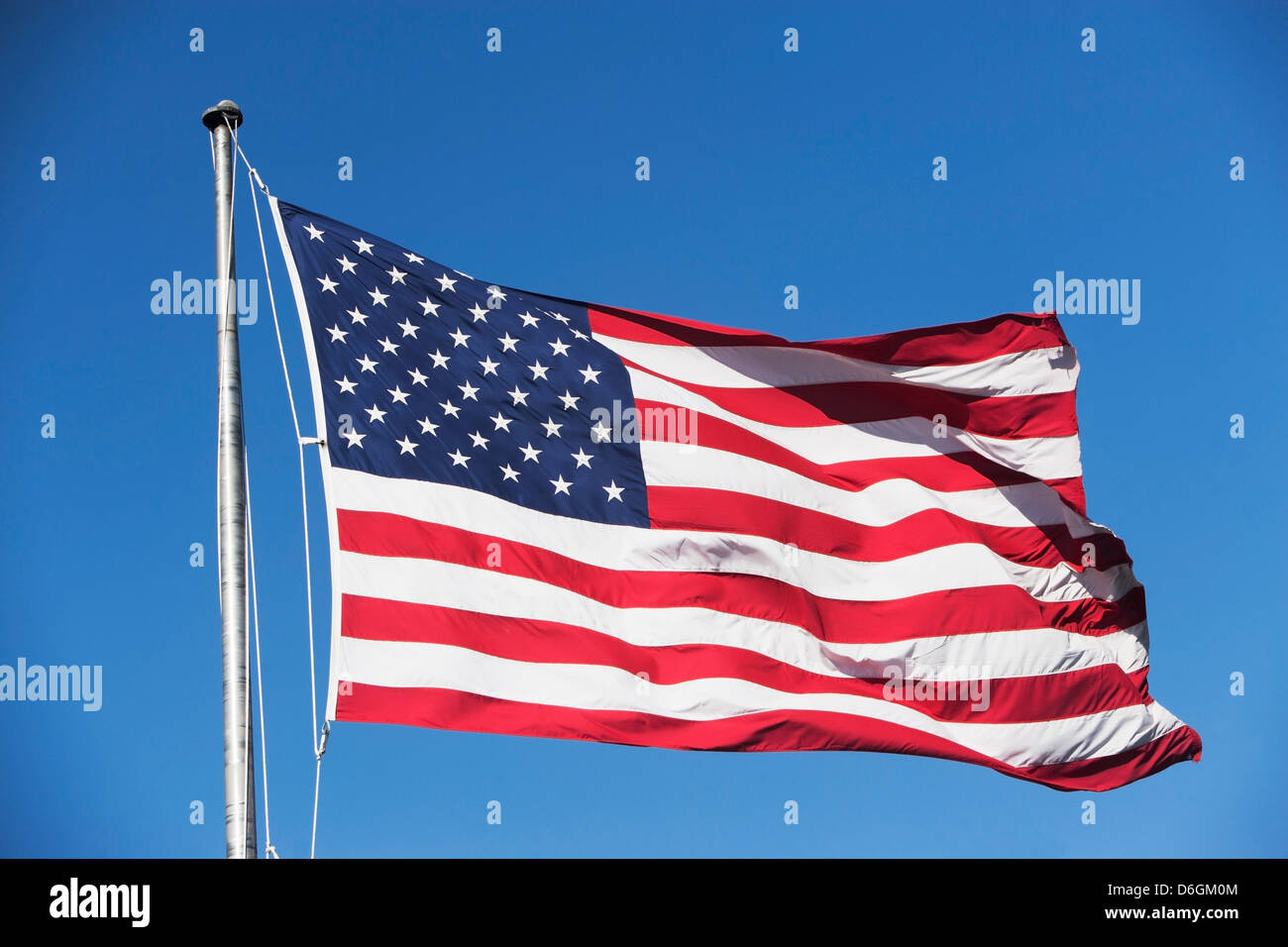 American flag waving in sky Stock Photo