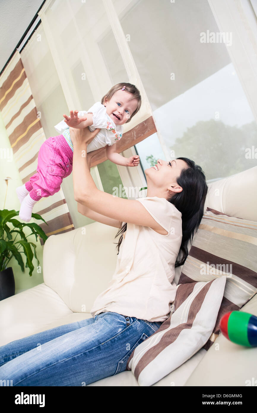 indoor portrait of a young woman with toddler twins in the living room Stock Photo