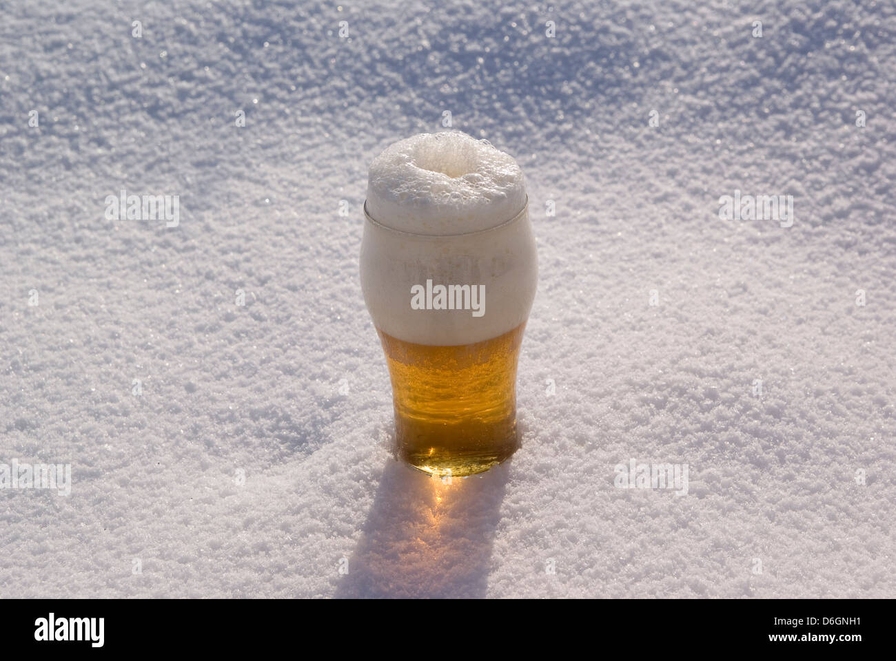 big beer in glass stands on snow Stock Photo