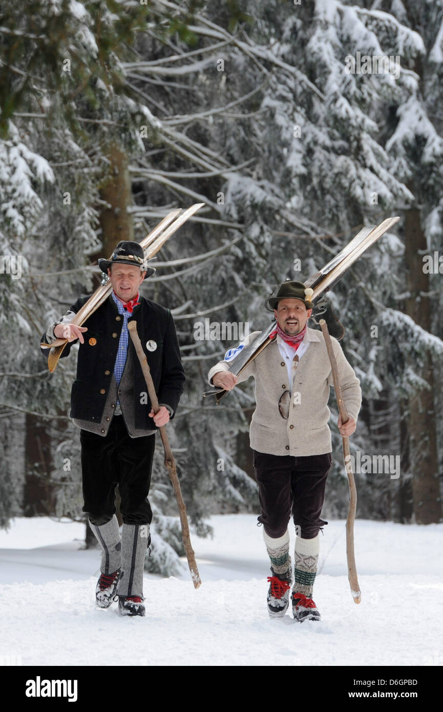 Skiers in historical costumes walk to the starting line on a piste in ...