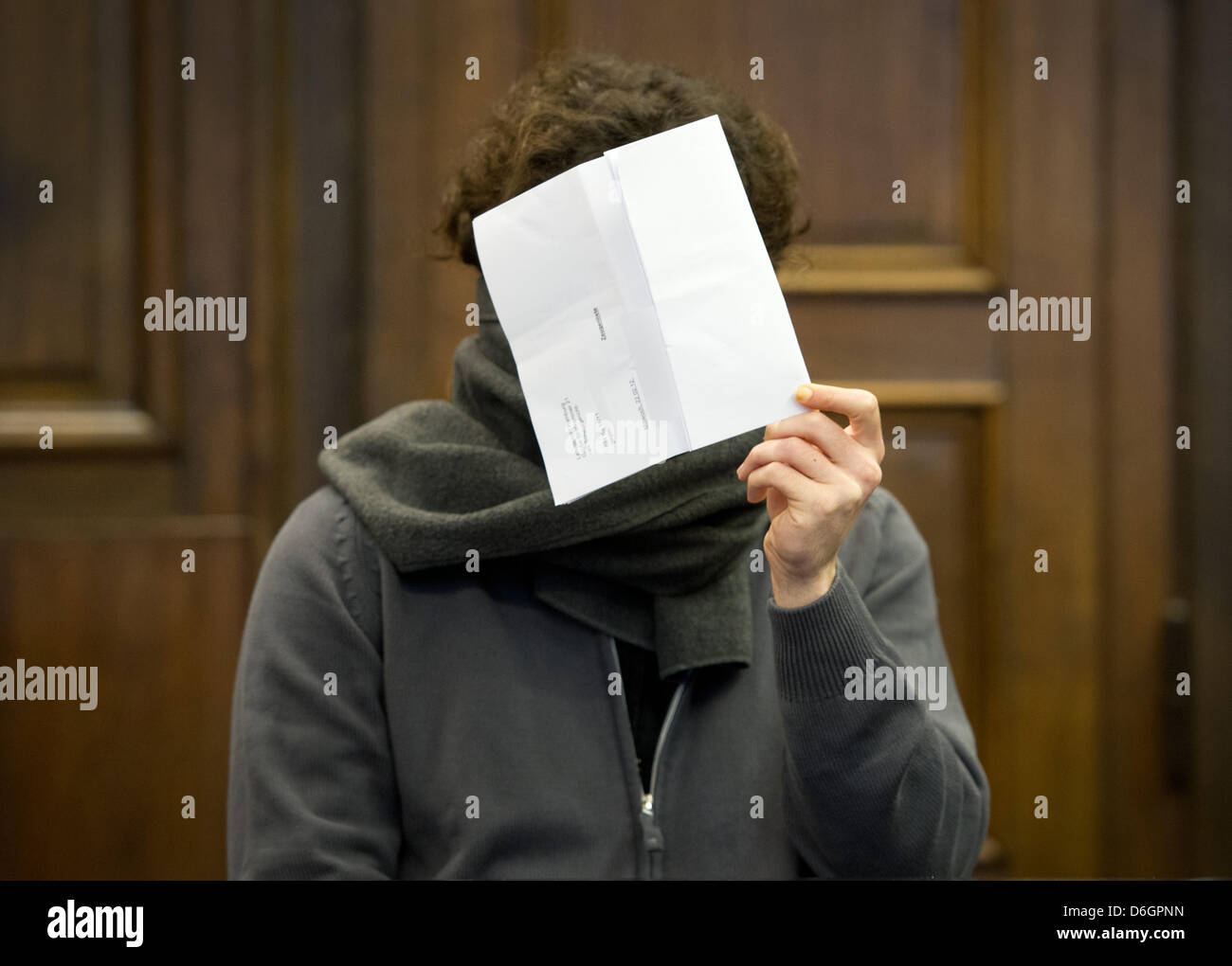 The 27 year old accused holds a piece of paper in front of his face at the District Court in Hamburg, Germany, 22 February 2012. The psychologically ill man is on trial for the murder of a younf US American woman in a Hamburg hotel. Photo: CHRISTIAN CHARISIUS Stock Photo