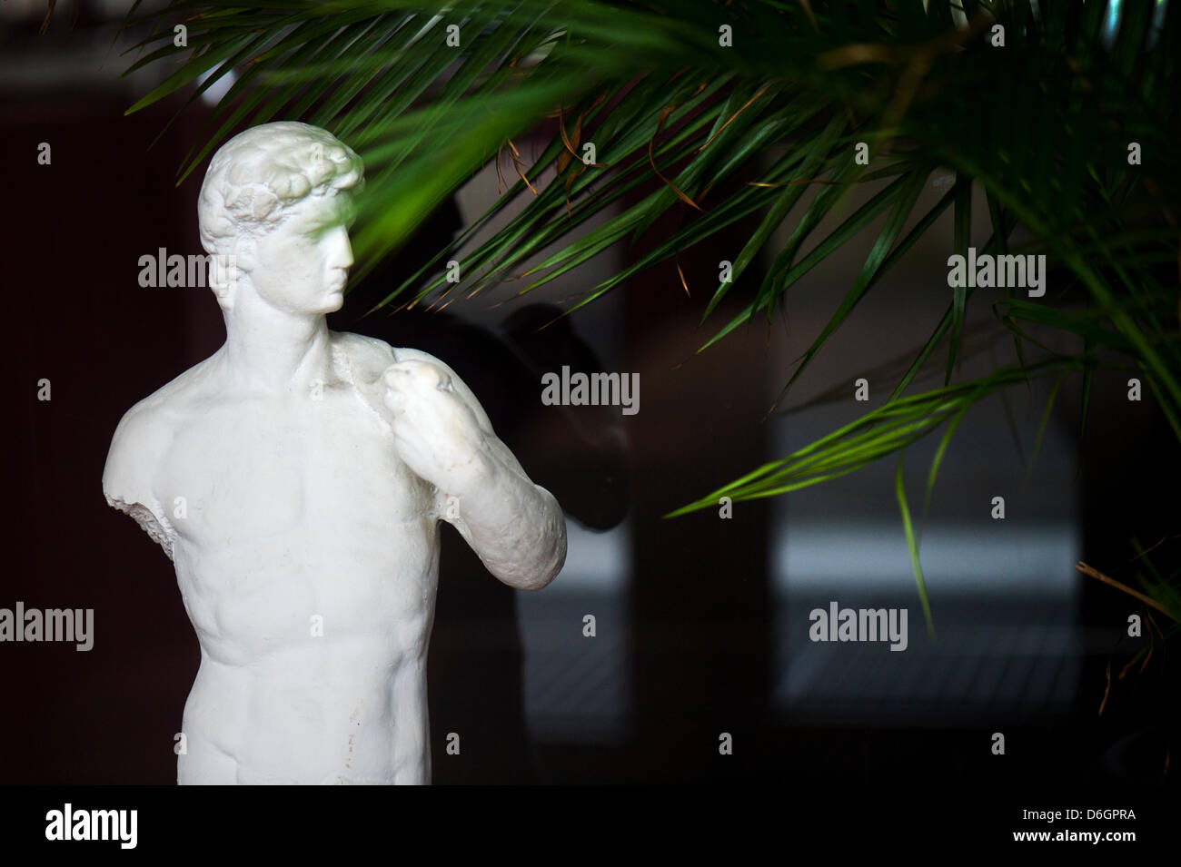 A male statue missing an arm is pictured in front of a Greek restaurant in Dresden. The
