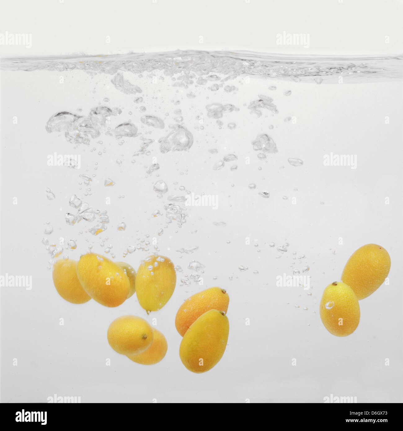 Kumquats splashing into water Stock Photo Alamy