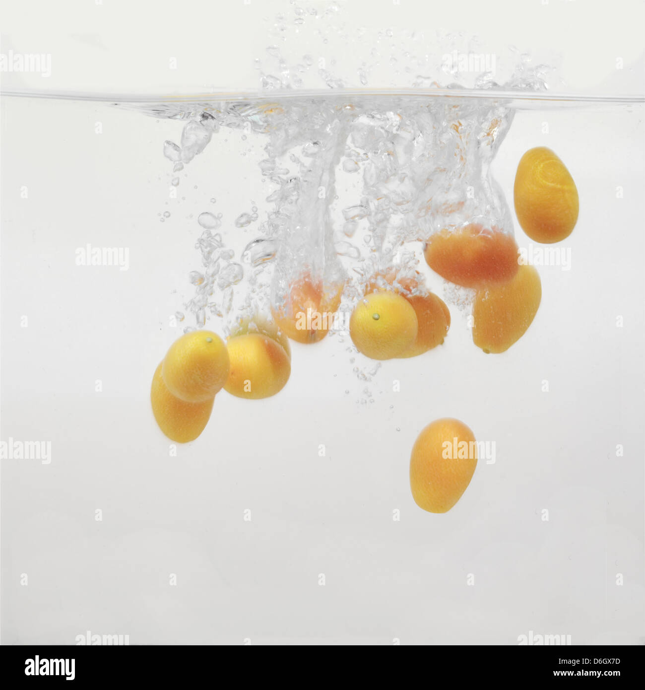Kumquats splashing into water Stock Photo Alamy