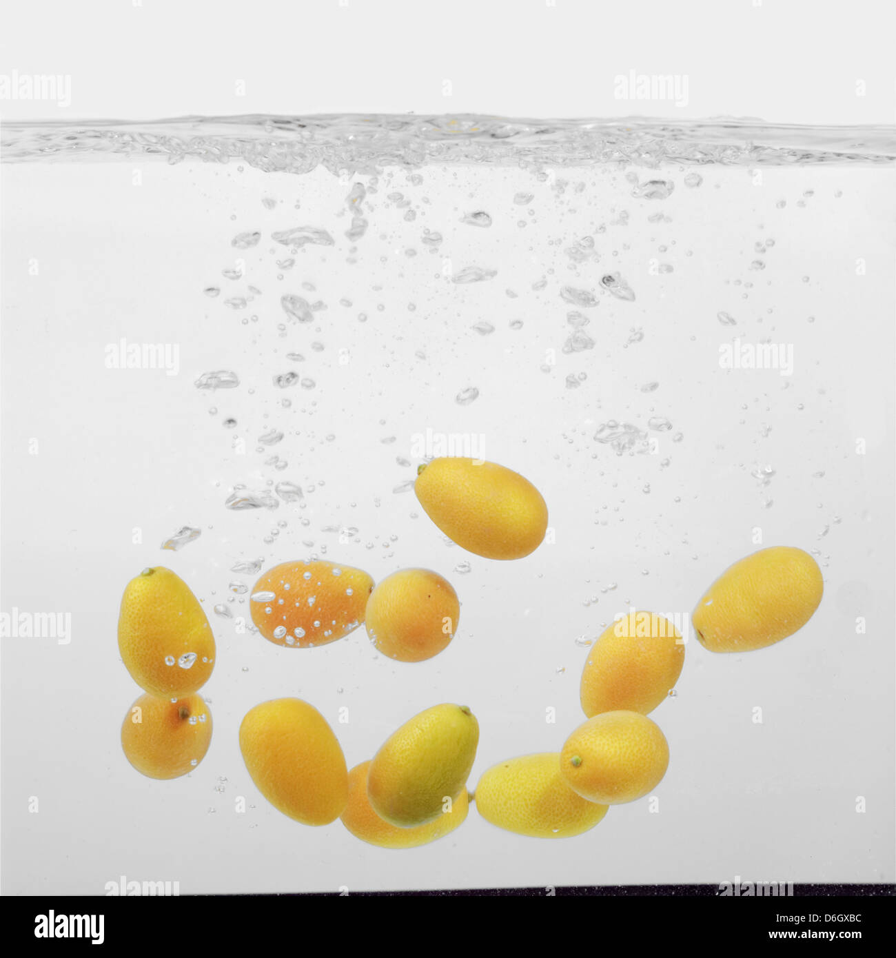 Kumquats splashing into water Stock Photo Alamy