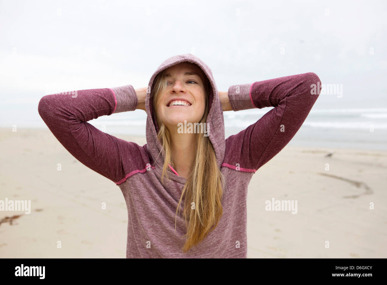 Woman wearing hoodie on beach Stock Photo Alamy