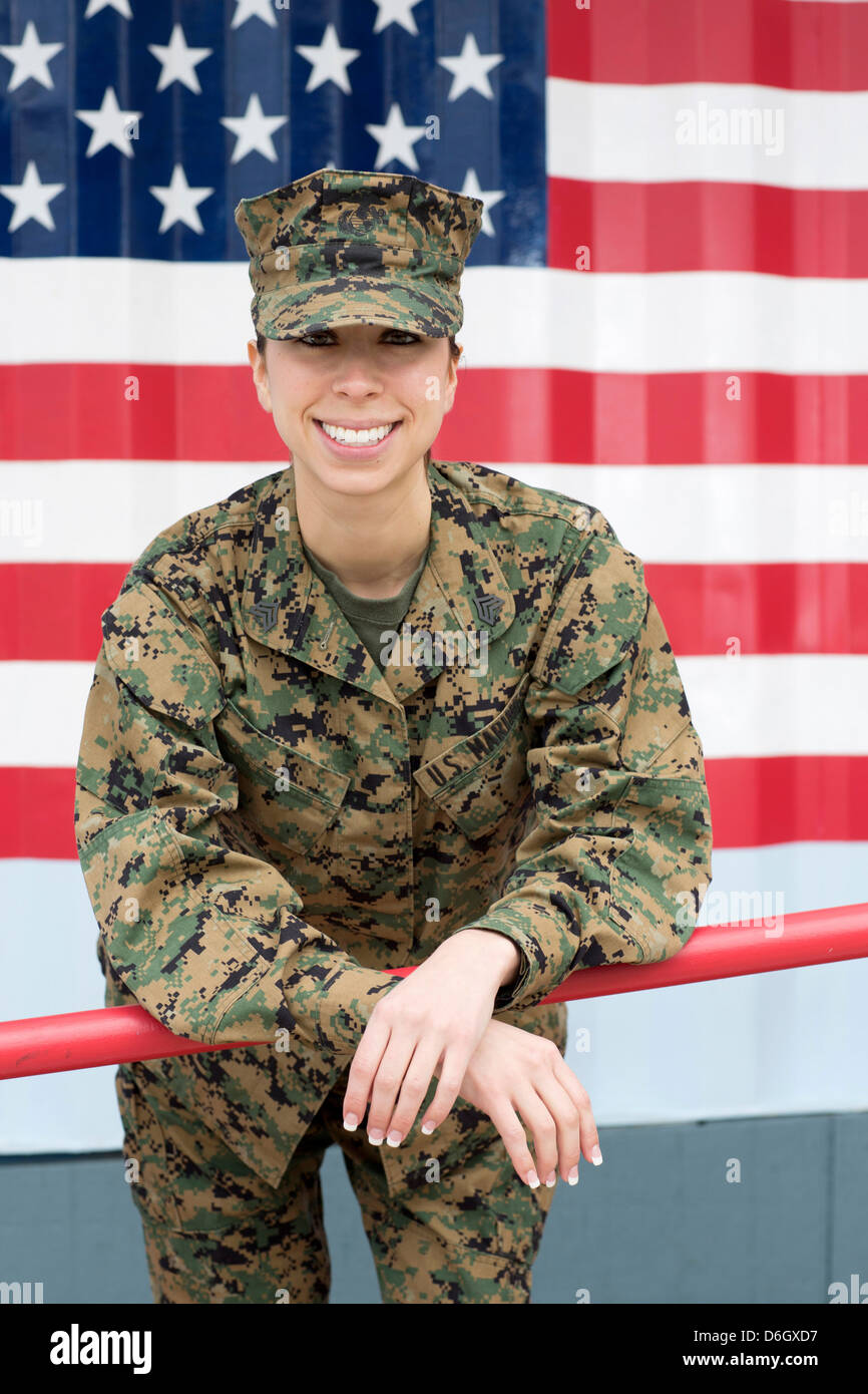Servicewoman in camouflage by US flag Stock Photo