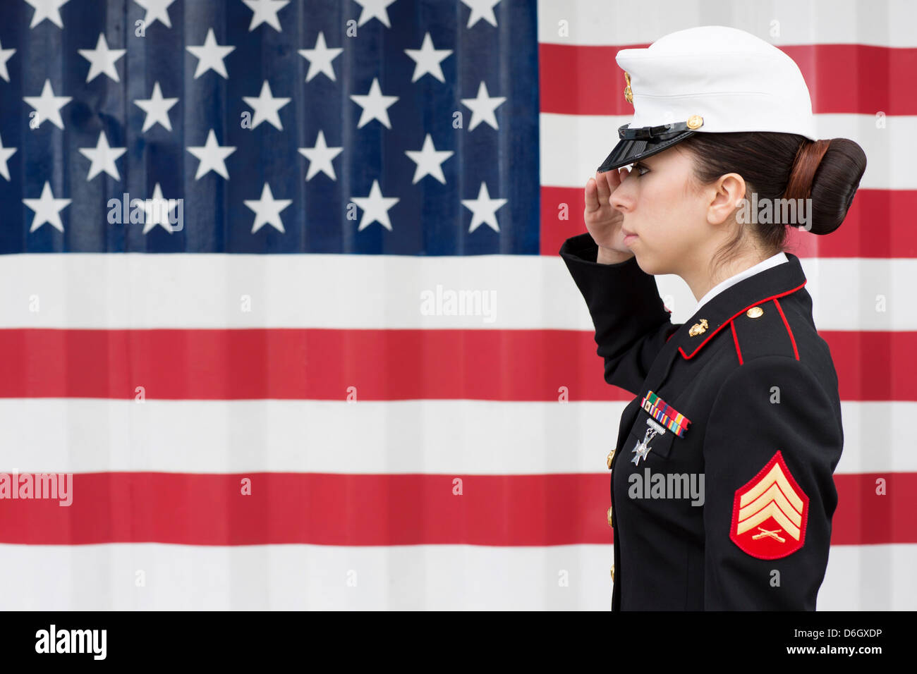 Servicewoman in dress blues by US flag Stock Photo