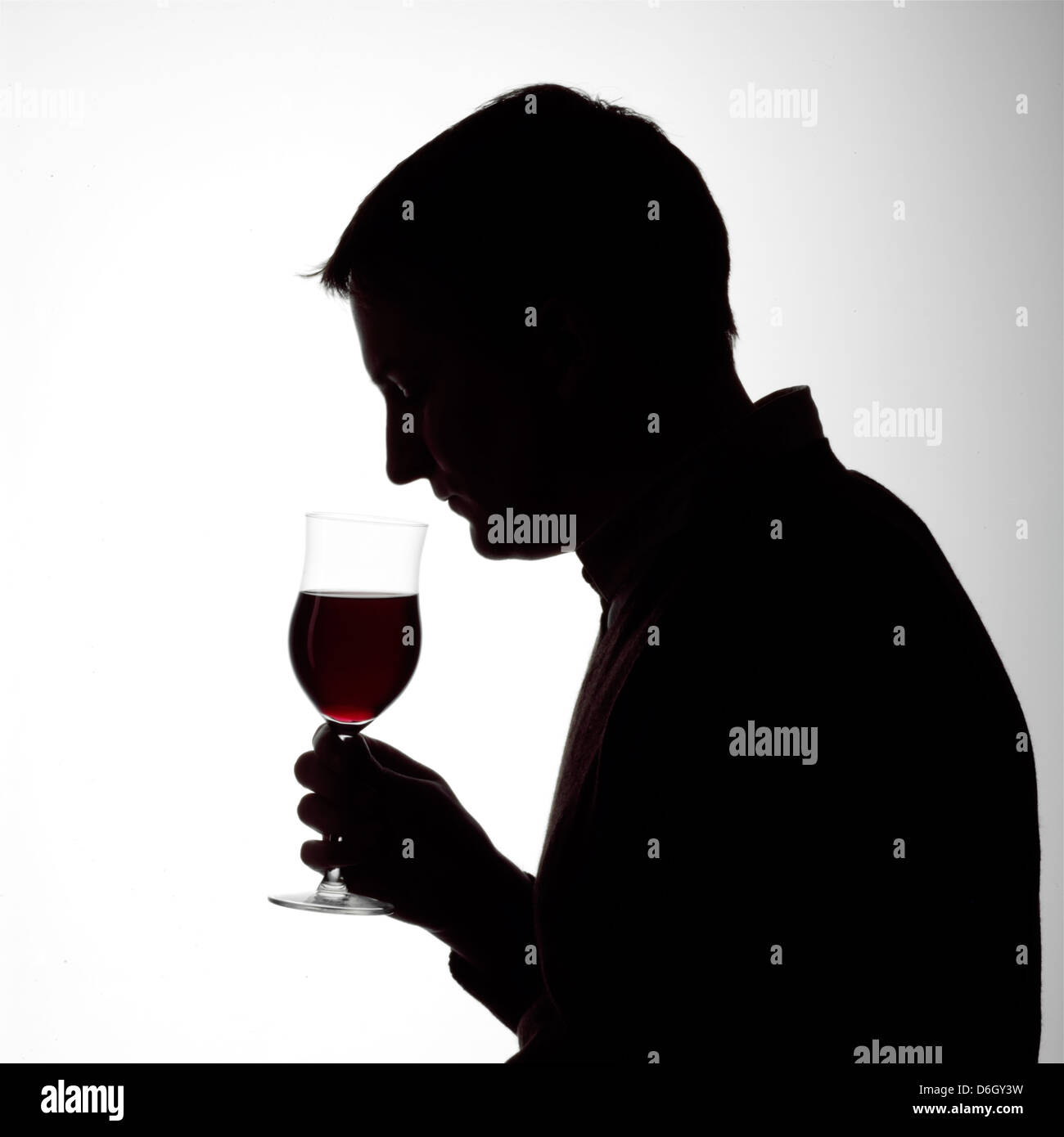 Silhouette portrait of a young man smelling a glass of red wine Stock ...
