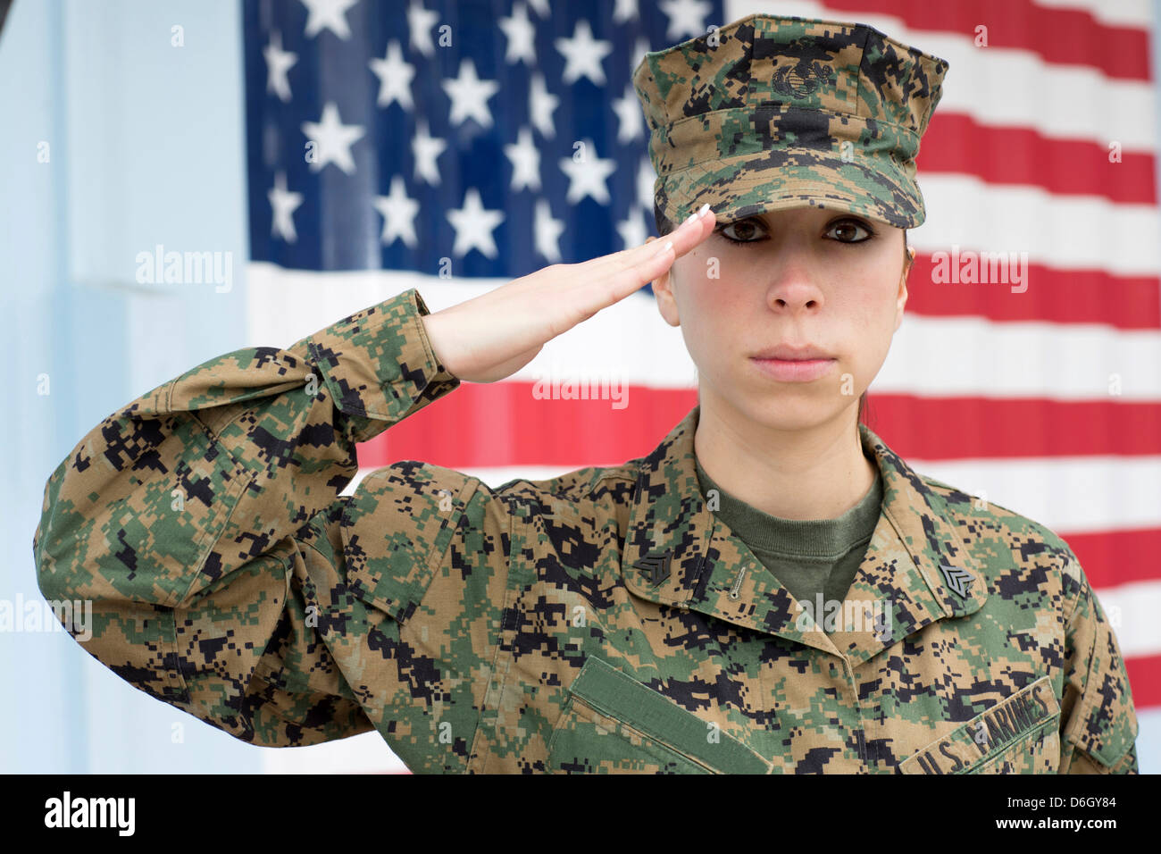 Servicewoman in camouflage by US flag Stock Photo