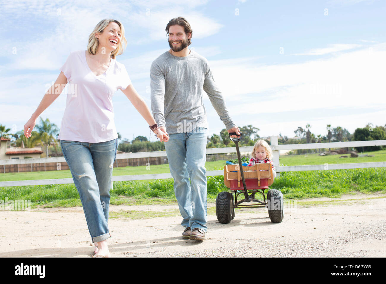 Parents pulling son in wagon Stock Photo