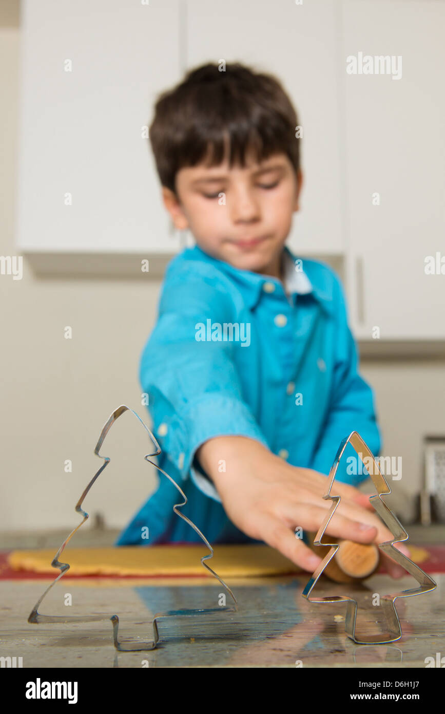 Boy using cookie cutters in kitchen Stock Photo Alamy