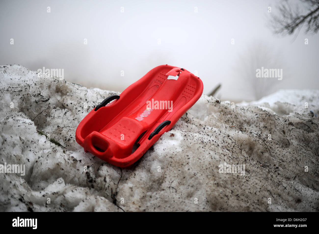 A broken child's sled sits on a dirty heap of snow in Hohen Meissner,  Germany, 28 February 2012. Photo: Uwe Zucchi Stock Photo - Alamy