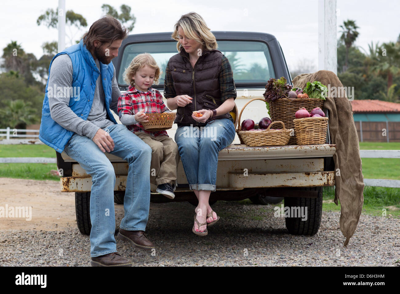 Family with produce in truck bed Stock Photo
