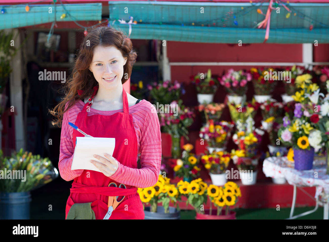Florist making notes in shop Stock Photo