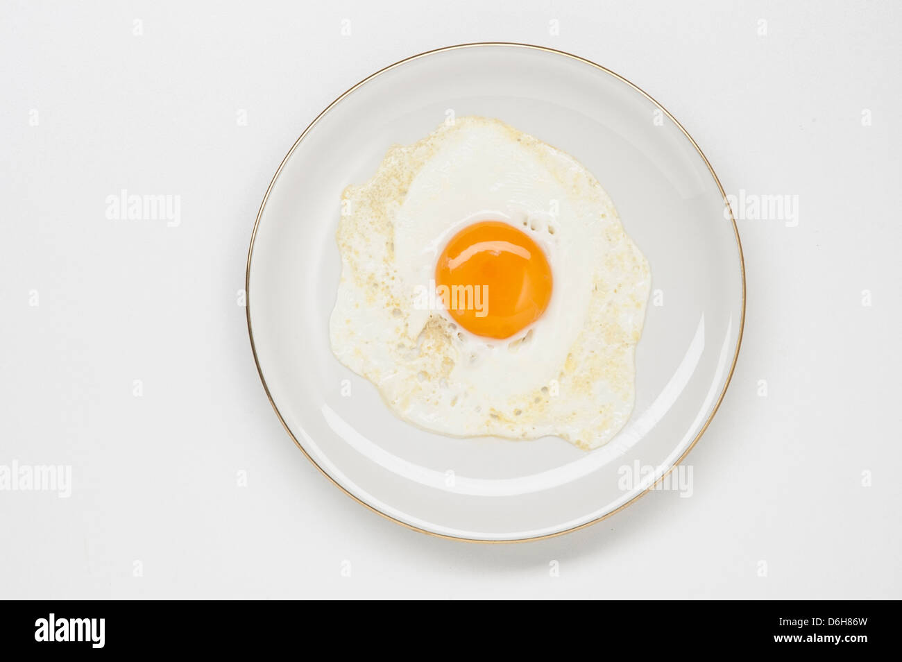 fried egg on white plate with golden border Stock Photo - Alamy