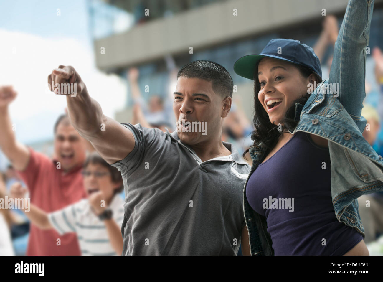 Couple cheering at sports game Stock Photo