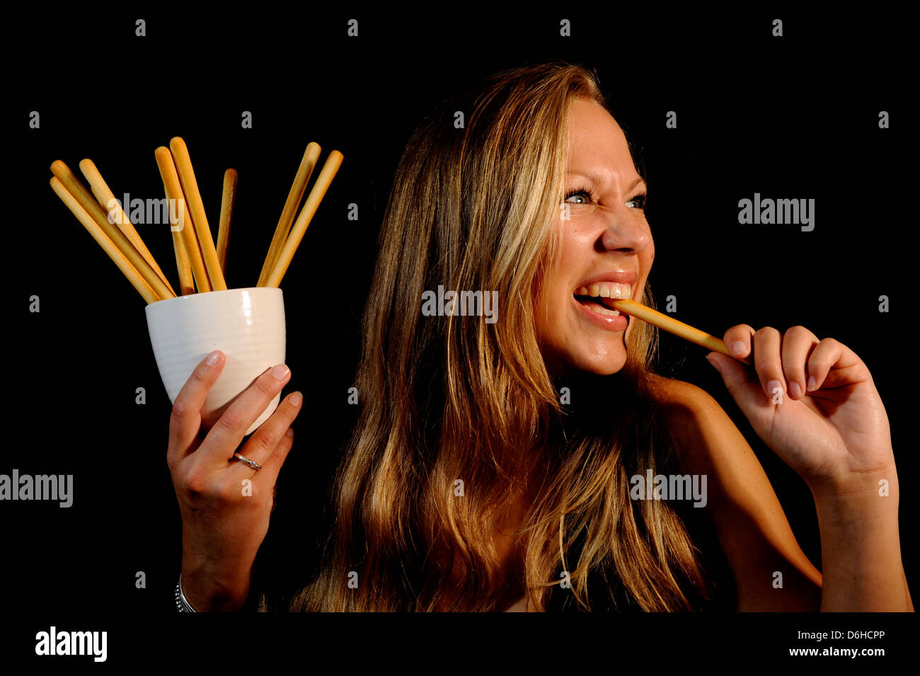 A young Blonde woman eating a Breadstick Stock Photo Alamy