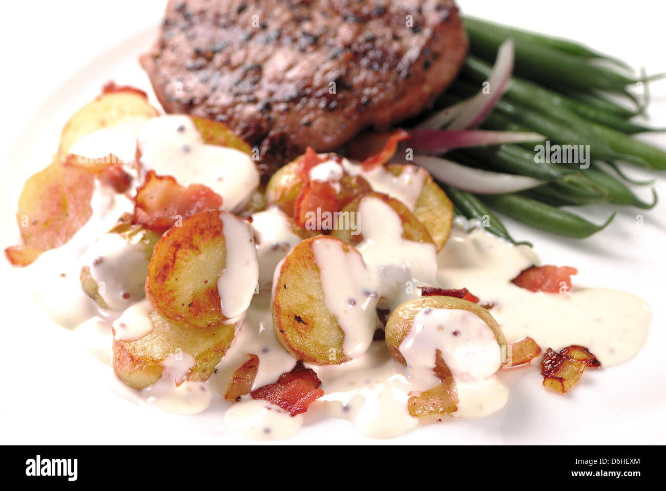 Saucy potatoes, steak and french beans Stock Photo