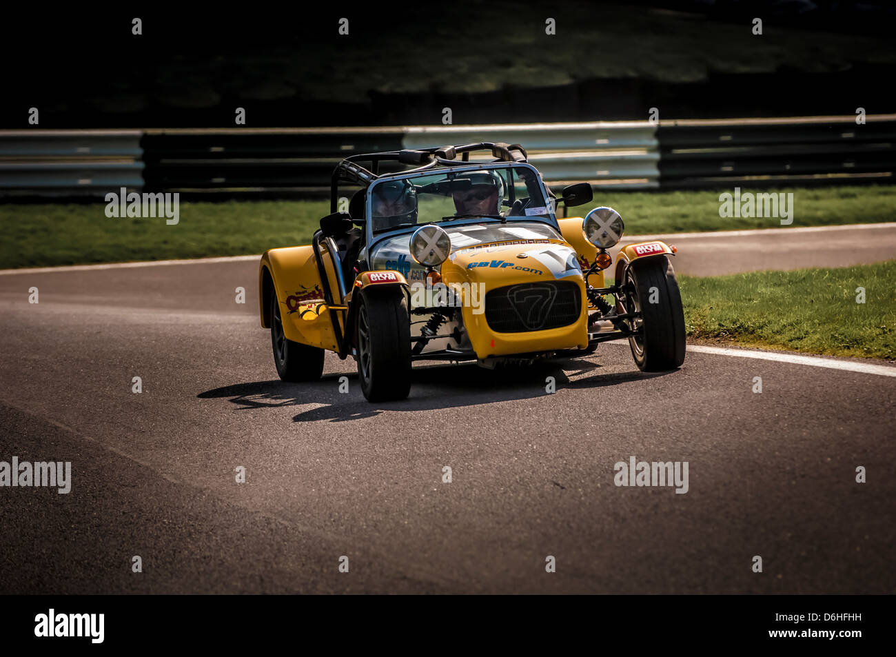 Yellow Caterham Seven car racing at Cadwell park race track. Stock Photo