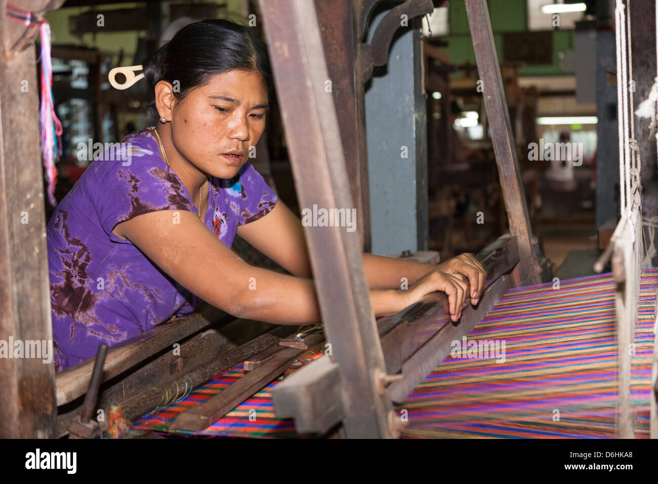 Woman weaving on a loom, Thein Nyo silk weaving workshop, Amarapura, Mandalay, Myanmar, (Burma) Stock Photo