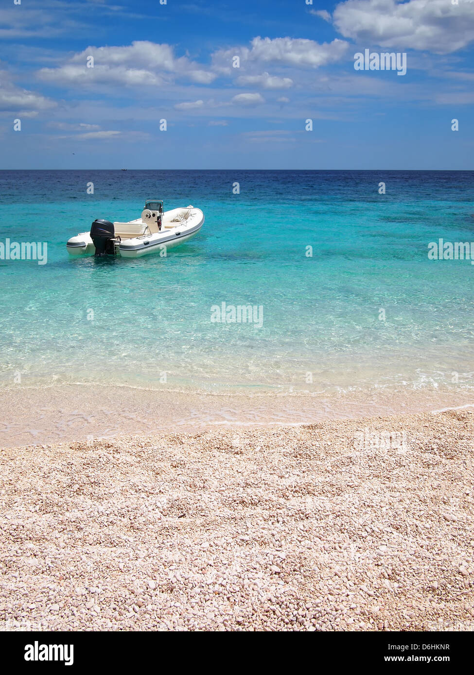 Speedboat in an emerald sea in front of a private white sand beach on the east coast of Sardinia, Italy. Stock Photo