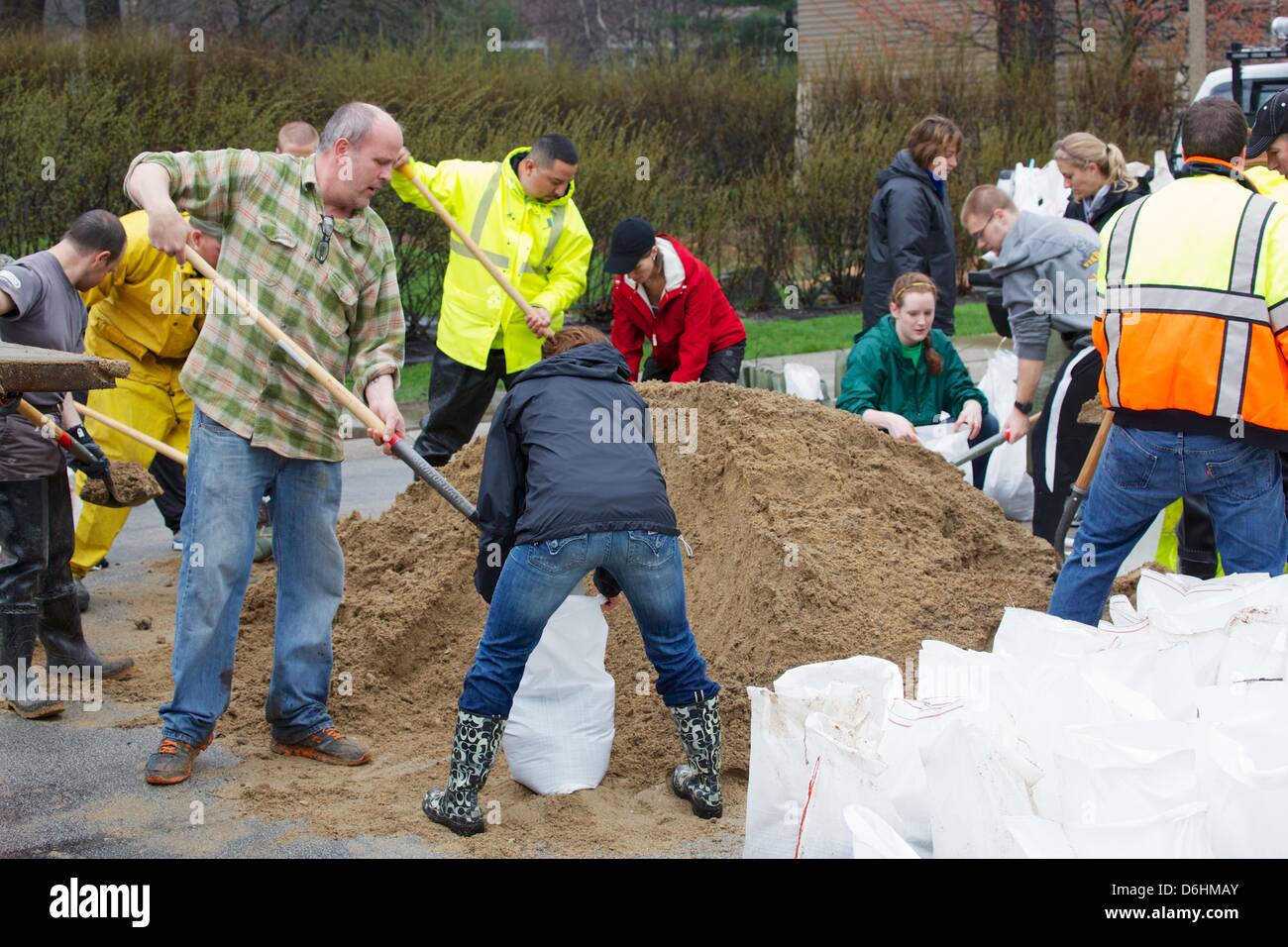 River Forest, Illinois, USA. 18th April 2013.  Volunteers fill sandbags on River Oaks Drive adjacent to the Des Plaines River. The river is expected to flood to record levels due to heavy rains. . Stock Photo