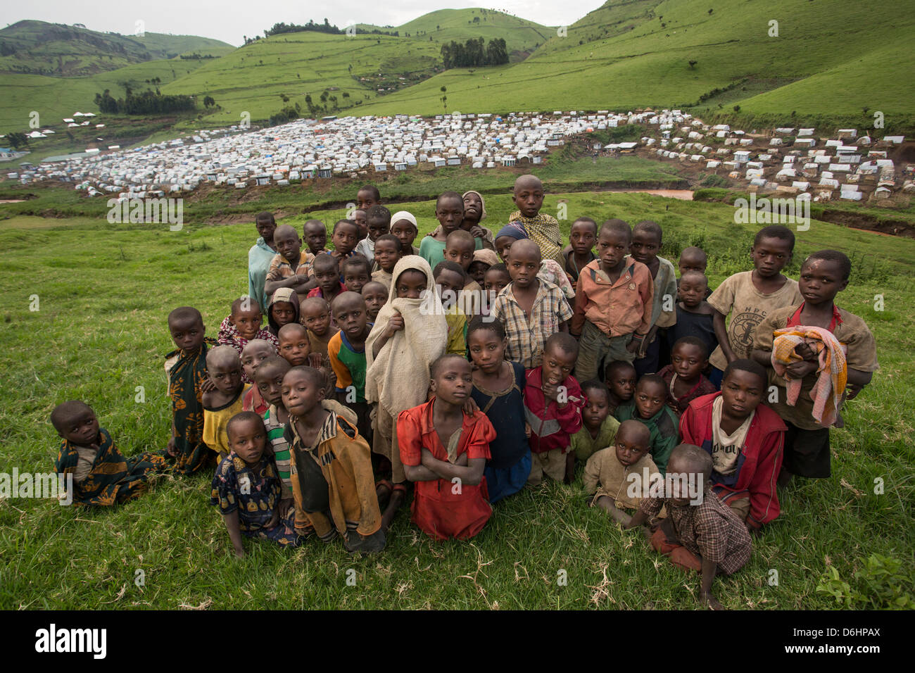 Children huddle together outside of Kishusha – Rubaya Camp in North Kivu Province in Eastern DRC. Stock Photo