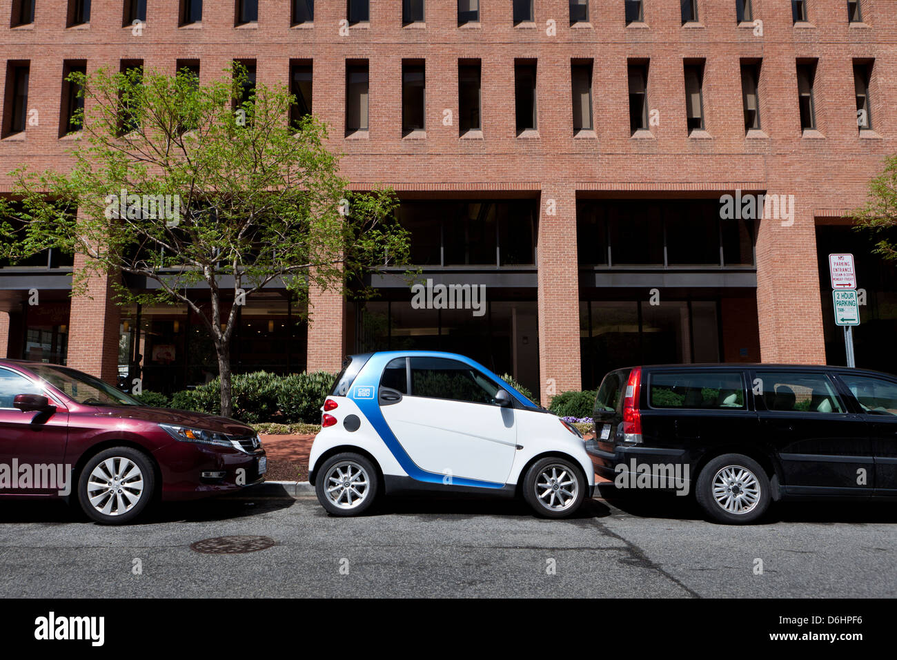 SmartCar parked in between two cars Stock Photo