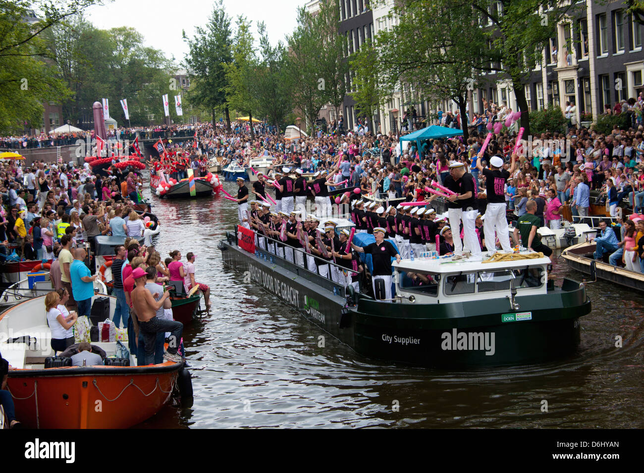 The Gay Pride Parade down a crowded canal lined with people and boats