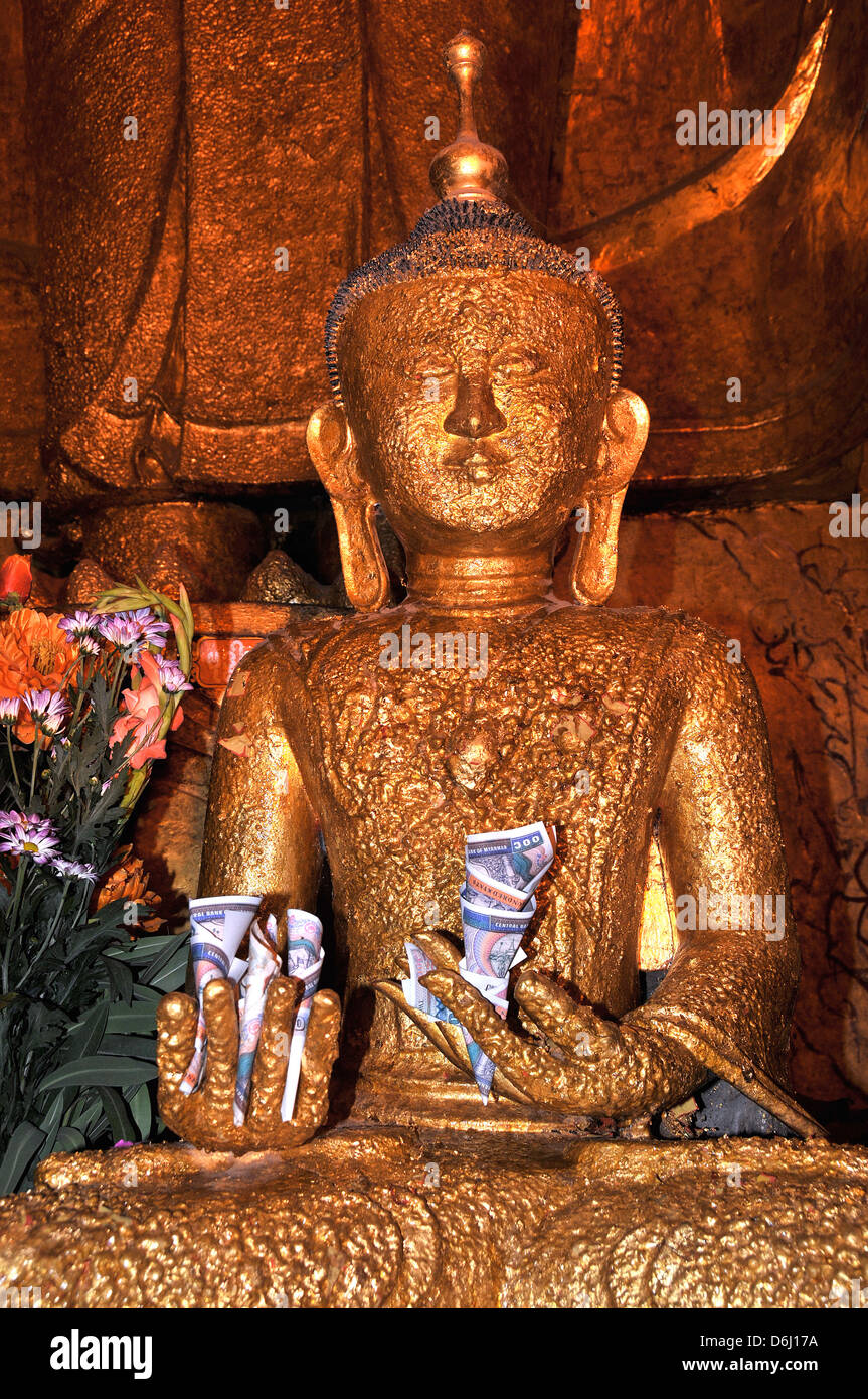 golden buddha statue with money in his hands, Bagan, Myanmar Stock Photo
