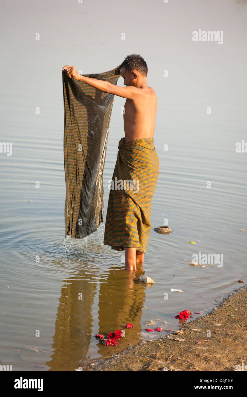 Man washing his clothes in Taungthaman Lake, Amarapura, Mandalay, Myanmar, (Burma) Stock Photo