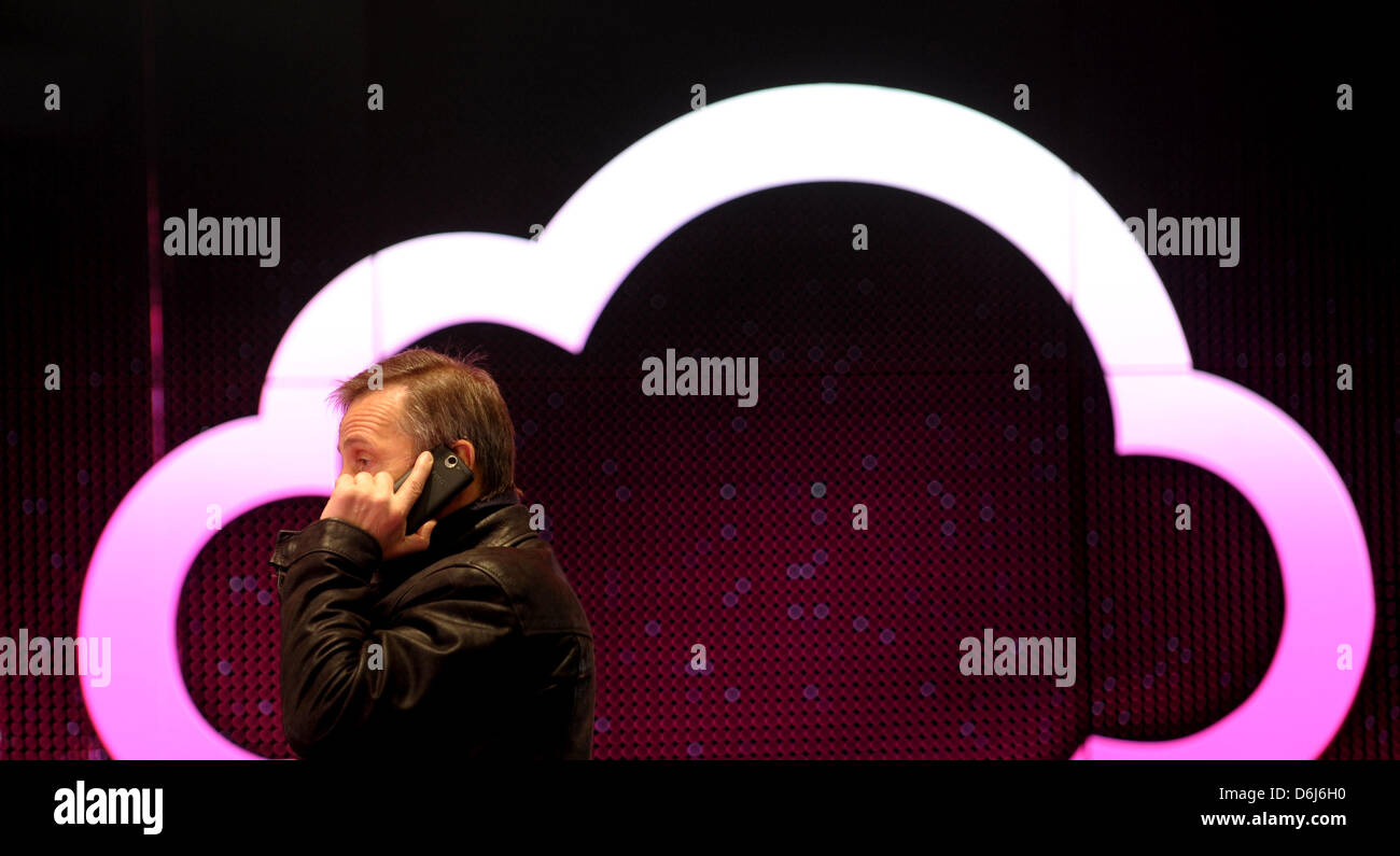 A man telephones in front of a cloud symbol at the German Telecom booth at the world's largest computer trade fair CeBIT in Hanover, Germany, 05 March 2012. From 06 to 10 March 2012, more than 4,200 companies from 70 countries present their products and new developments at the CeBIT 2012. Photo: PETER STEFFEN Stock Photo