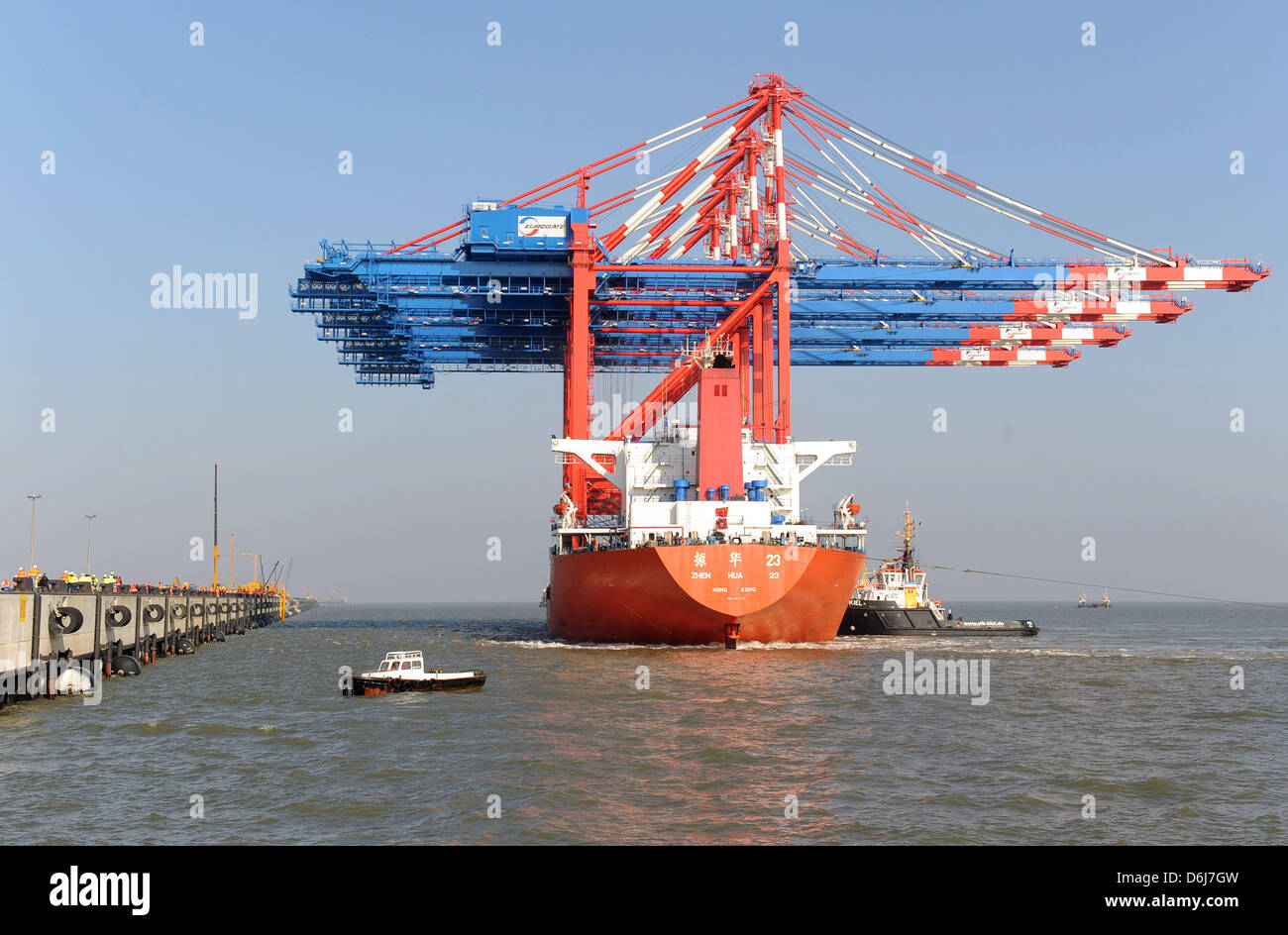 A cargo vessel loaded with giant gantry cranes arrives at the pier of