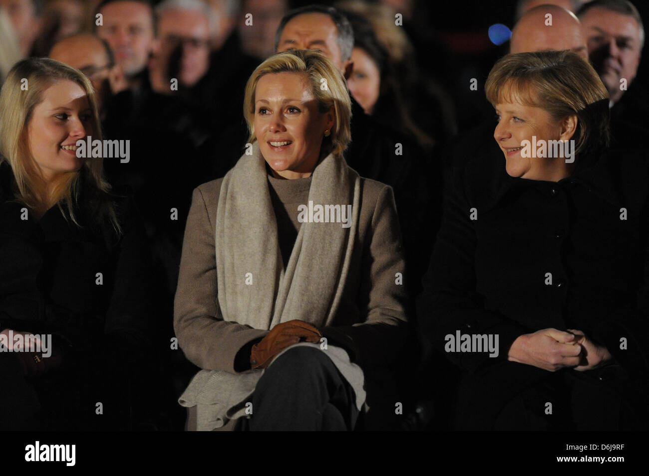 Wife of former German president Christian Wulff, Bettina Wulff, sits next to German Chancellor Angela Merkel (R) and Wulff's daughter of his first marriage, Annalena, during the Grand Tattoo (Grosser Zapfenstreich) for former German president Christian Wulff in front of Bellevue Palace in Berlin, Germany, 08 March 2012. Wulff resigned on 17 February 2012 after accusations of taking Stock Photo