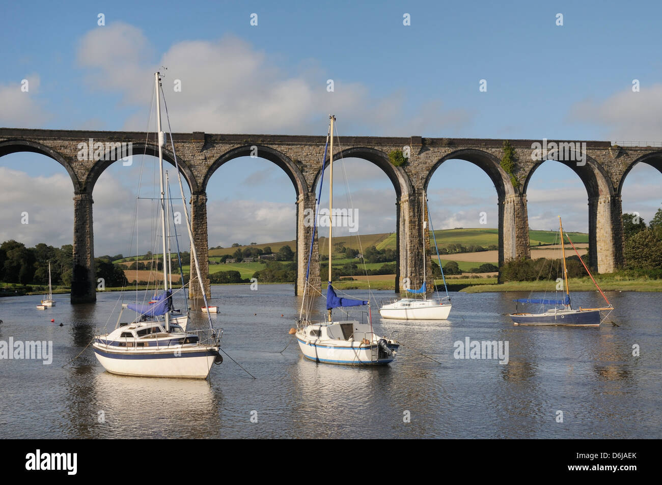 Sailing yachts moored in the River Lynher at high tide below St. Germans railway viaduct, Cornwall, England, UK Stock Photo