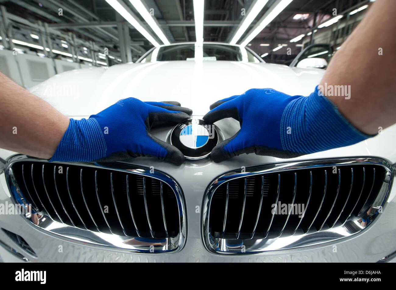 A BMW emblem is placed onto a 3 Series vehichle at the BMW factory in Regensburg, Germany, 07 March 2012. BMW hat the best year in the company's history thanks to record sails in 2011. Photo: ARMIN WEIGEL Stock Photo