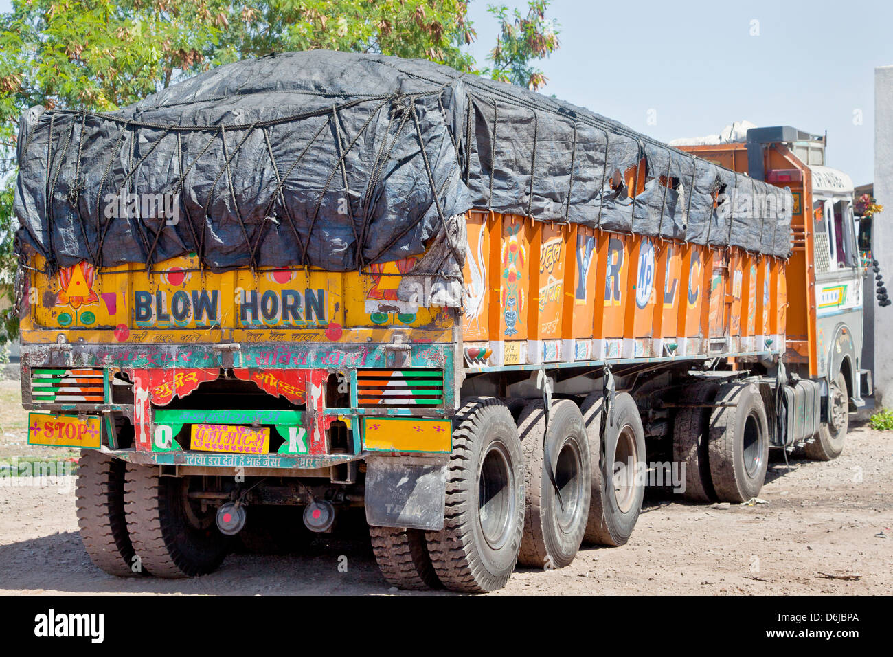 Colorful Indian heavy goods vehicle parked up at Dhabha (Indian truck stop) in the mid day sun Stock Photo