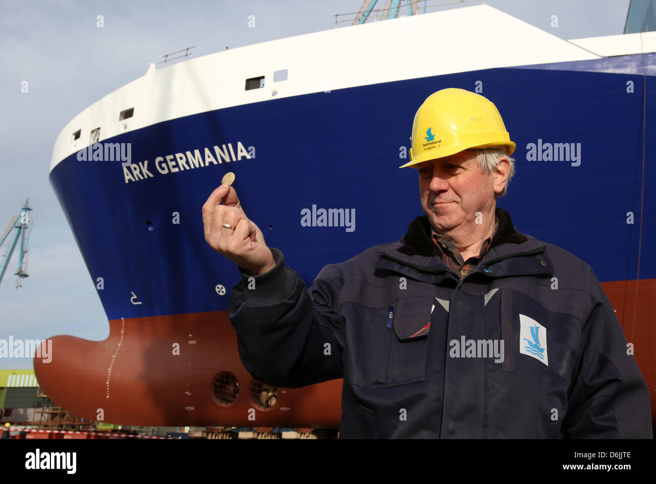 Juergen Kraeplin, member of the board of the Stralsund Volkswerft since 1992, shows a ten cent coin, which he layed underneath a section of the ship during the laying down of a keel, while the first of two cargo ships for the Danish shipping company DFDS is rolled out of the shipyard of bankrupt shipbuilding company P+S in Stralsund, Germany, 19 April 2013. After examinations, the 195m long RoRo-special ship shall be put to water and completed. Photo: Bernd Wuestneck Stock Photo