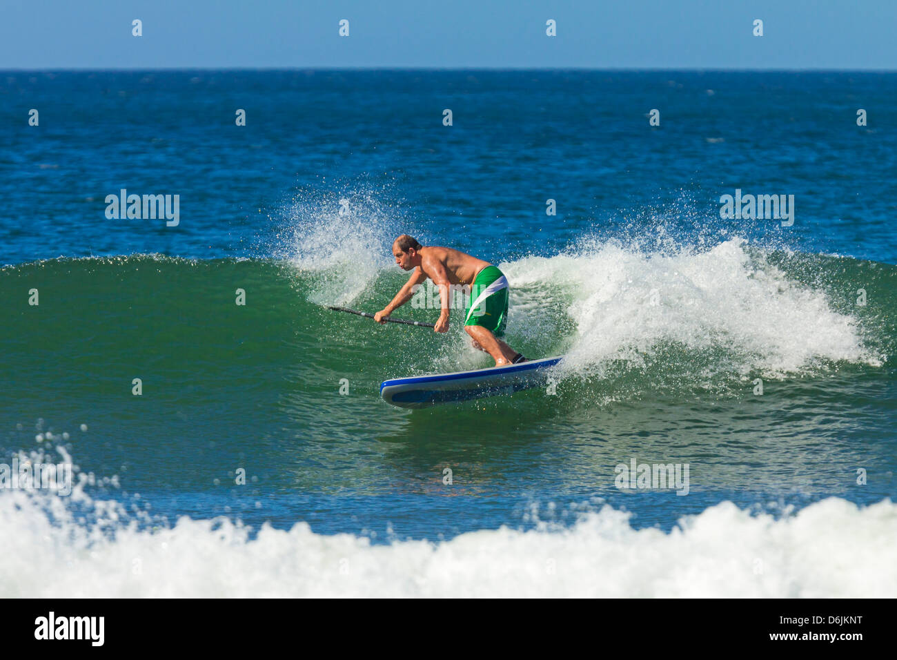 Man surfing inflatable paddle board at Playa Guiones beach, Nosara, Nicoya Peninsula, Guanacaste Province, Costa Rica Stock Photo